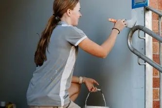 A woman painting the stairs of a building.