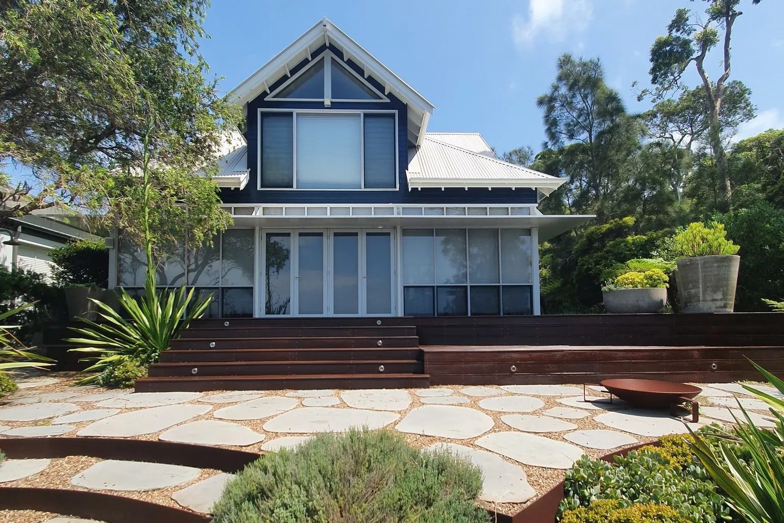 A residential painting project for a house with a wooden deck and steps.