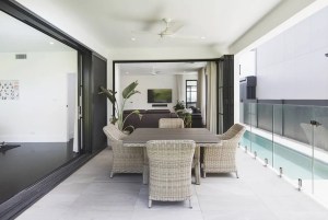 A balcony with a table and chairs overlooking a swimming pool.