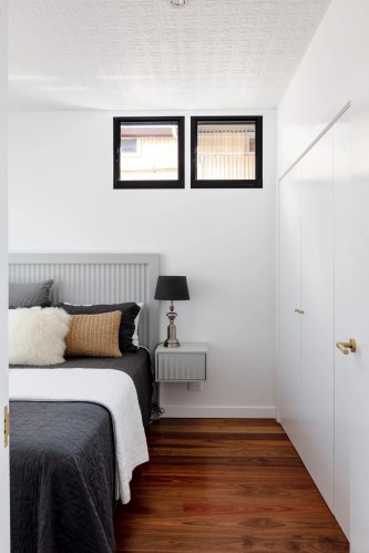 A white bedroom with wooden floors and a bed. A white bedroom with wooden floors and a bed.